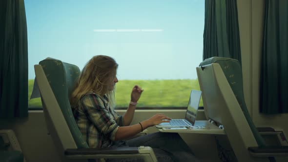 Young Woman Work on Laptop When Commute By Train alt