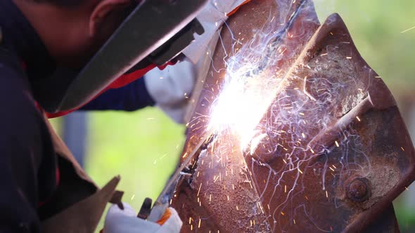4K Asian man welder working on welding machine in construction factory. alt