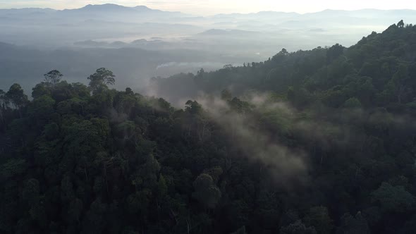 Aerial view Drone flying through the fog above mountain peak alt