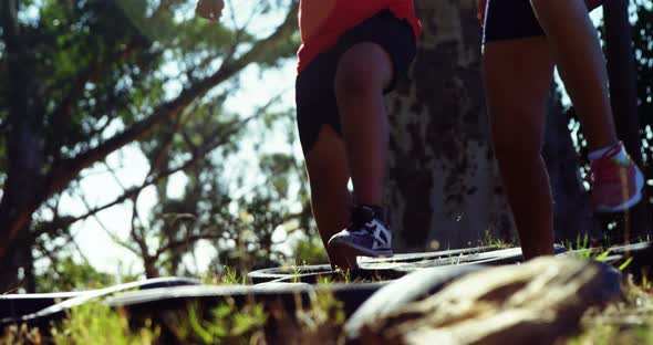 Kids running over tyres during obstacle course training alt