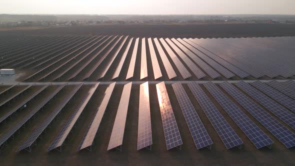Aerial Drone View Into Large Solar Panels at a Solar Farm at Early Spring Sunset alt