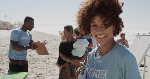 Female volunteer looking at camera on the beach 4k alt