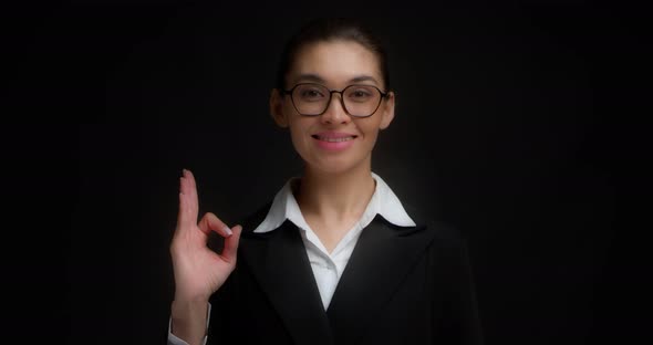 Business Woman in Glasses with a Smile on Her Face Shows Ok Sign