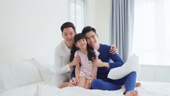 Portrait of handsome man gay family with young kid daughter sit on bed in morning in bedroom., Stock Footage 