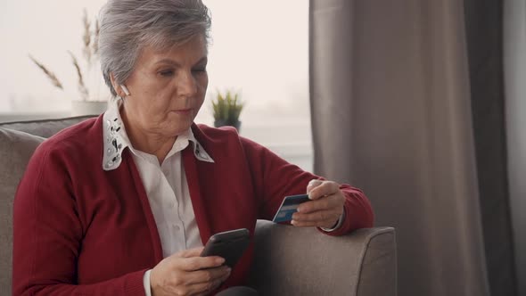 Retired Woman with Cellular and Credit Card in Hands