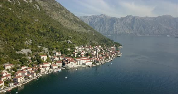 Aerial shot of Perast in Montenegro, on the Bay of Kotor with a mountain ridge in the distance alt