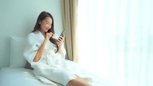 Young asian woman use smart phone alt