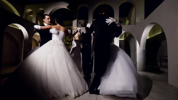 Women in Gorgeous Dresses and Gentlemen in Black Suits are Dancing in Ballroom Viennese Ball alt