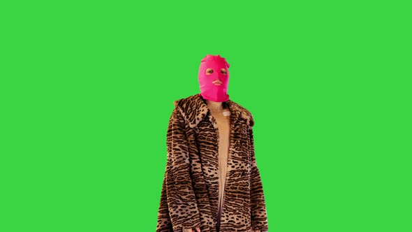 Young Girl in Pink Balaclava and Leopard Coat Dancing Slightly on a Green Screen Chroma Key