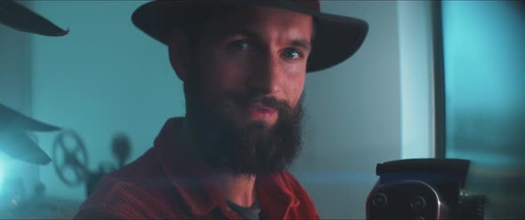A young man adjusts 35mm Camera alt