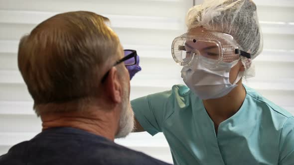 Hospital Worker Takes Patient's Smear To Test for Coronavirus. alt