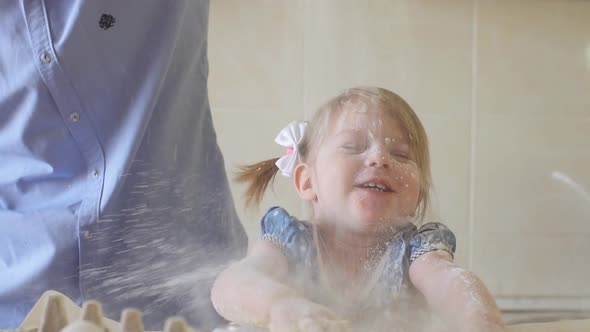 Joyful Little Girl with Dad in the Kitchen Playing with Flour, Slow Motion.