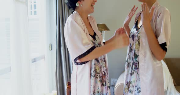 Excited bridesmaids in nightdress and hair rollers hugging each other 4K 4k alt