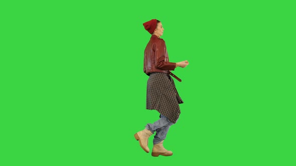 Young Girl in Stylish Urban Clothes Walks Dancing Slightly Snapping Fingers on a Green Screen Chroma alt