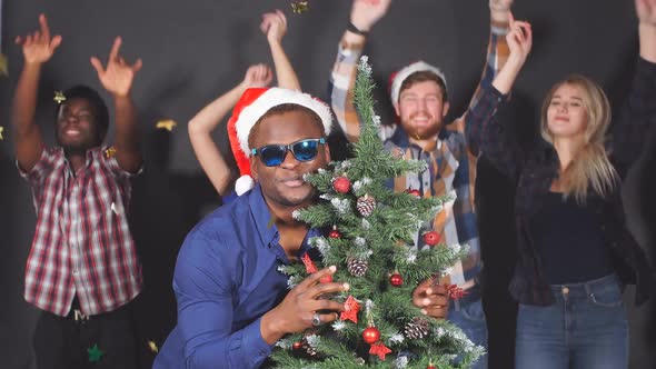 Multi Ethnic Group of Young People at Christmas Party in Studio Dancing and Smiling Into Camera