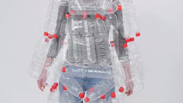 Dehydrated Sick Woman Is Lying in a Pile of Plastic Bottles. Environmental Pollution Problem. Stop alt