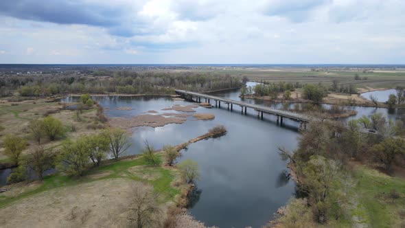 Flying over the river. Cars crossing the bridge