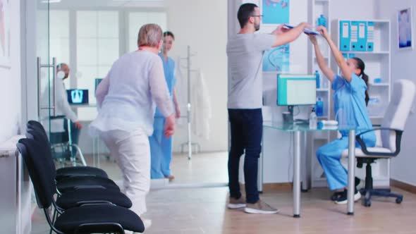 Young Man Filling Documents in Hospital Waiting Area alt