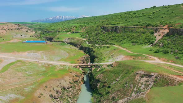 Aerial View on Metal Bridge and Car with Tourists Over Deep Canyon Aksu Kazakhstan alt
