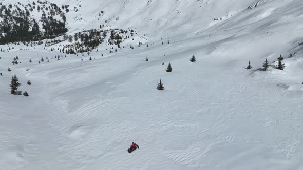 Snowmobile high in the mountains aerial view 4 K alt