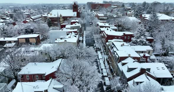 Aerial reveal above street during winter snow. Night shot in evening. Reverse aerial dolly shot. alt