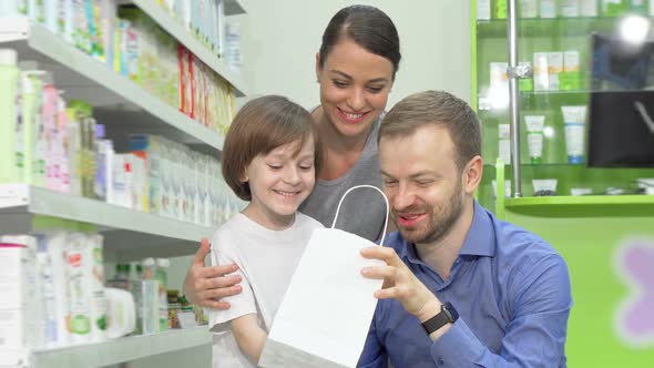 Lovely Family Examining Their Pharmacy Purchase in a Shopping Bag