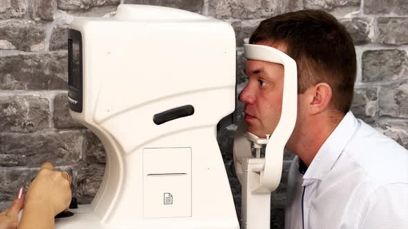 Portrait of Man During Test on Refractometer Machine