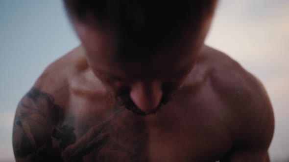 Drops of water is draining from exhausted male athlete face, workout in outside gym alt