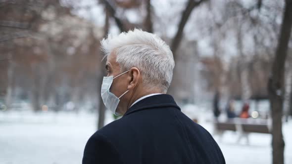 Gray Haired Gentleman Taking a Walk in Winter Garden During Covid 19 Lockdown alt