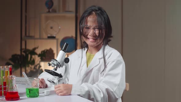 Young Scientist Girl With Dirty Face Looking At Microscope And Smiles To Camera In Laboratory alt