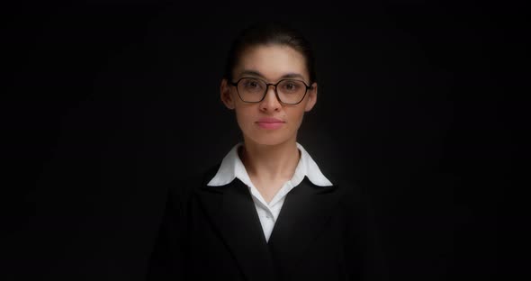 Asian Business Woman in Glasses and Formal Clothes Smiles and Looks at Camera