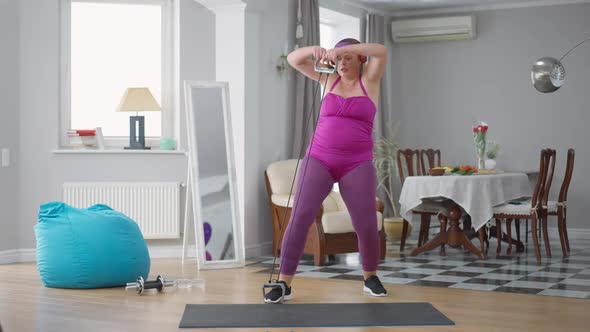 Funny Obese Woman Using Resistance Band Training Indoors alt