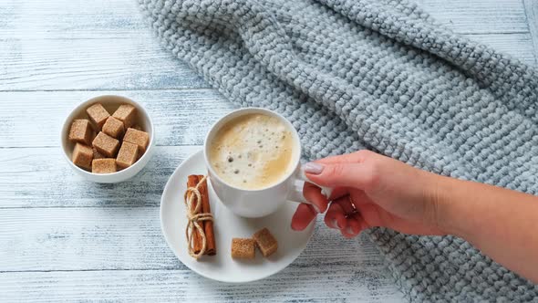 Female hands holding a mug with coffee