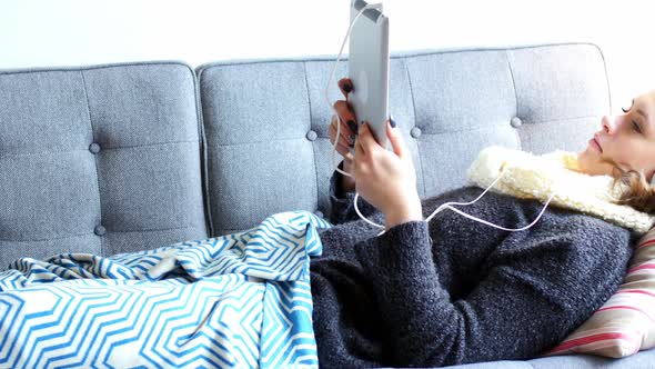 Beautiful woman using digital tablet in living room alt