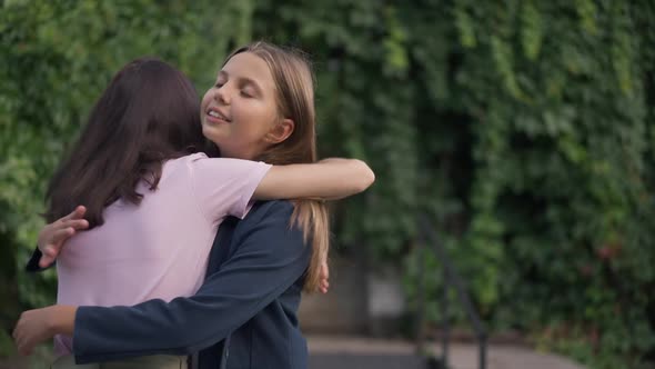 Hypocritical Insincere Teenage Girl Hugging Friend with Annoyed Facial Expression alt