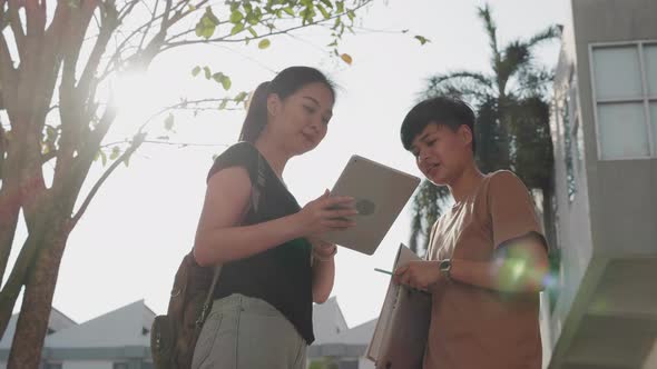 Education and student. Two Asian student talking with digital tablet in college.