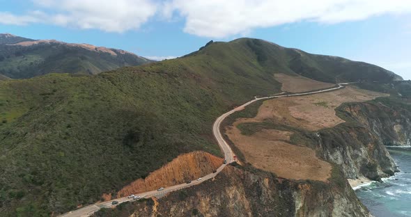 Aerial Drone Stock Video of Bixby Bridge Highway with water and shore below in Big Sur Monterrey Cal alt