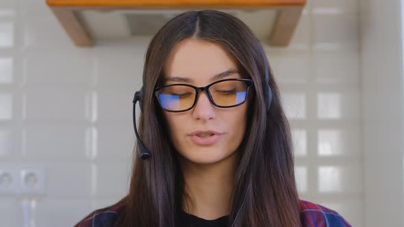 IT support operator in headset talking on microphone and web camera in laptop computer in 4k alt
