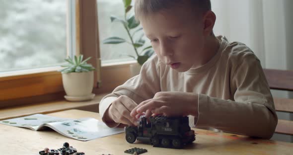Concentrated Boy Playing with Erector Set Indoors Close Up Slow Motion