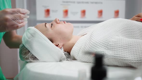 Female Beautician Makes Face Rejuvenation and Cleansing Procedure for Girl alt