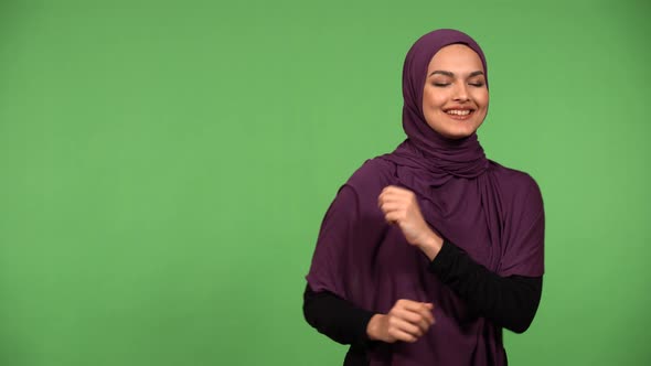 A Young Beautiful Muslim Woman Dances with a Smile  Green Screen Background