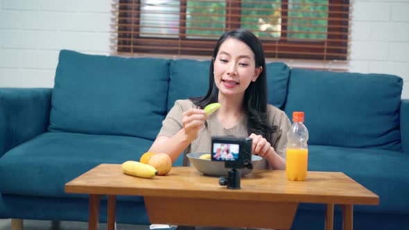 Asian women using camera streaming and recording vlog video about the benefit for broadcast online. alt