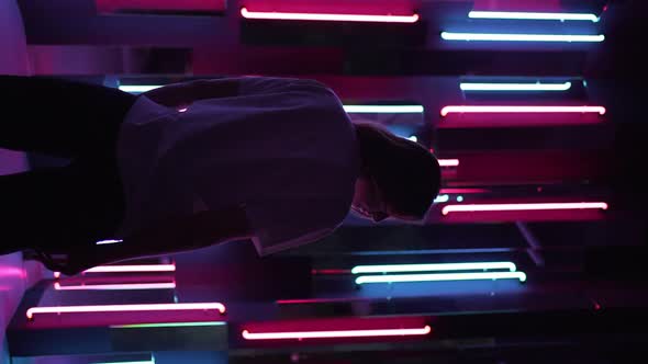 Vertical Video  Silhouette of a Young Woman Against the Background of Bright Neon