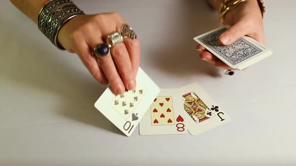 Female Hands With Gold Jewelery Lays Out Playing Cards.