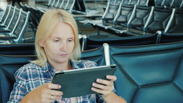 The Passenger in the Airport Lounge Uses a Tablet alt