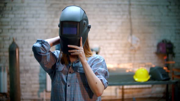 Young Sexy Woman Standing in the Workshop on the Background of Sparks alt