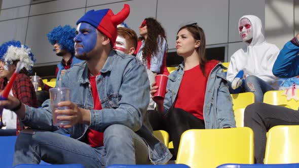 Brightly Dressed Sports Fans Watching Match at Stadium alt