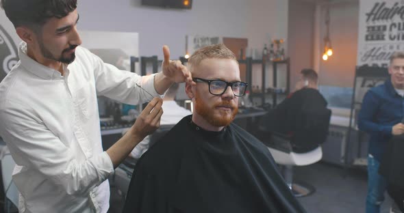 Young Hairdresser Using Fire To Remove Hair From Customer Ears alt