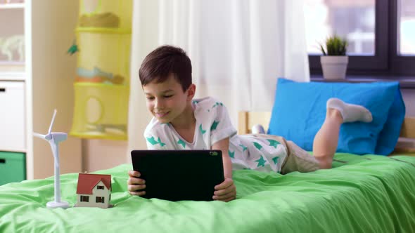 Boy with Tablet Pc and Wind Turbine Toy at Home 15 alt