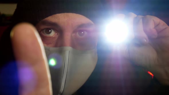 Male wearing virus mask checking worldwide contamination with torch light alt